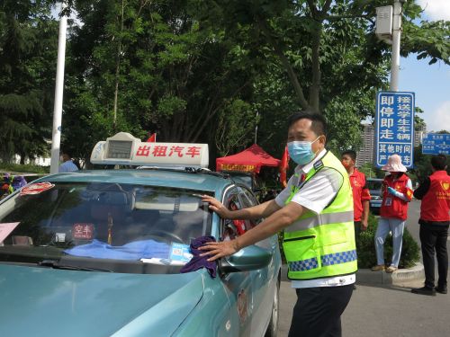 胶州尚合好司机公益负责人王振凯在考场外助考