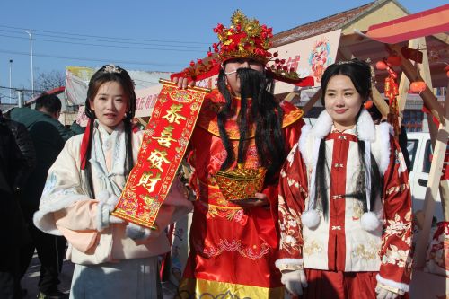 于家新村非遺年味大集上穿漢服的小姐姐與“財(cái)神爺”合照